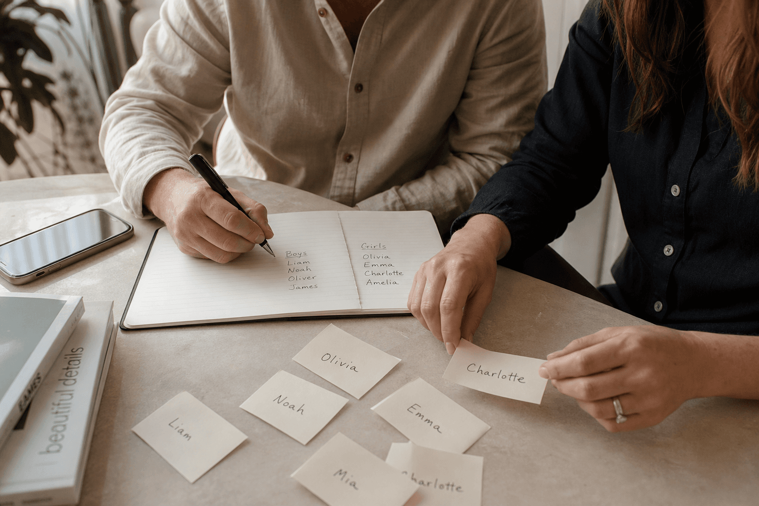 Parents comparing rising baby names at a table.